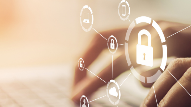 Hands typing on a keyboard overlaid by icons representing cybersecurity