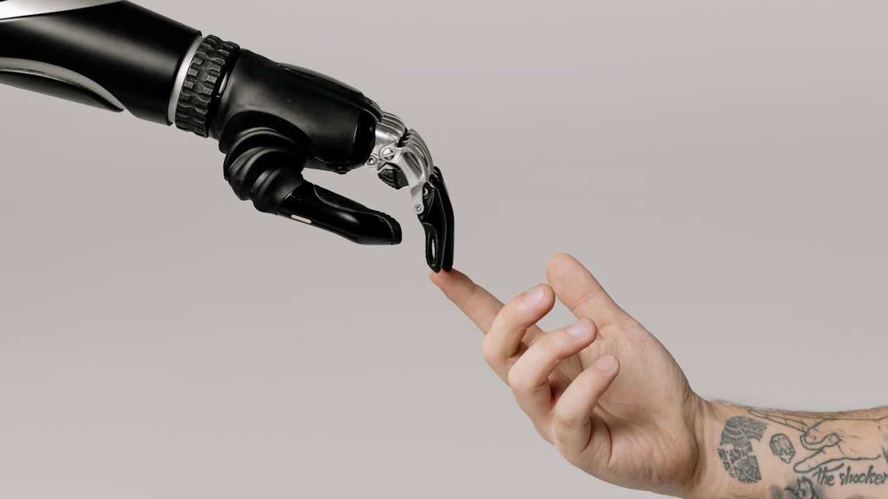A robot arm touching the fingers of a human arm