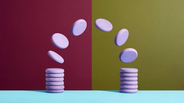 Two stacks of white discs with several more discs floating in an arc between the two. One half of the background is red and the other yellow, indicating differences.